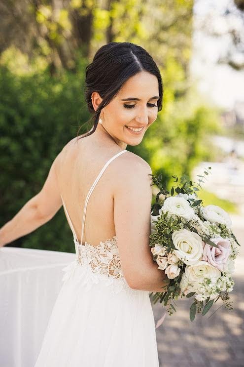 Bride smiling with bouquet outdoors