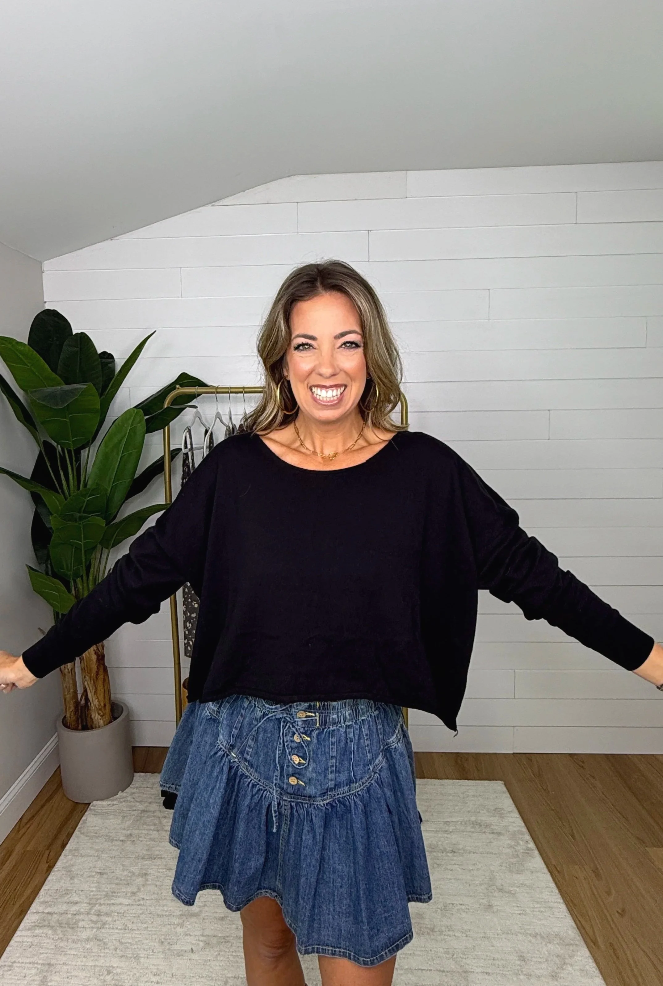 Black knit crop top with raw edge hem styled with a button front denim mini skirt