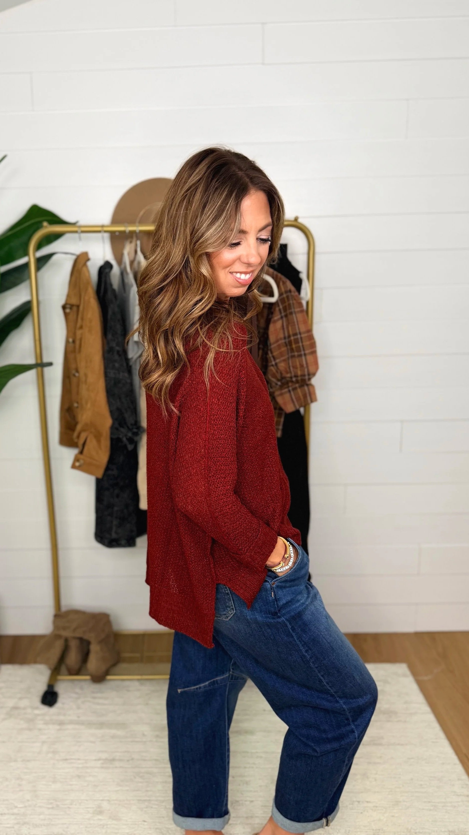 Side view of wine v-neck knit sweater showing oversized, relaxed silhouette