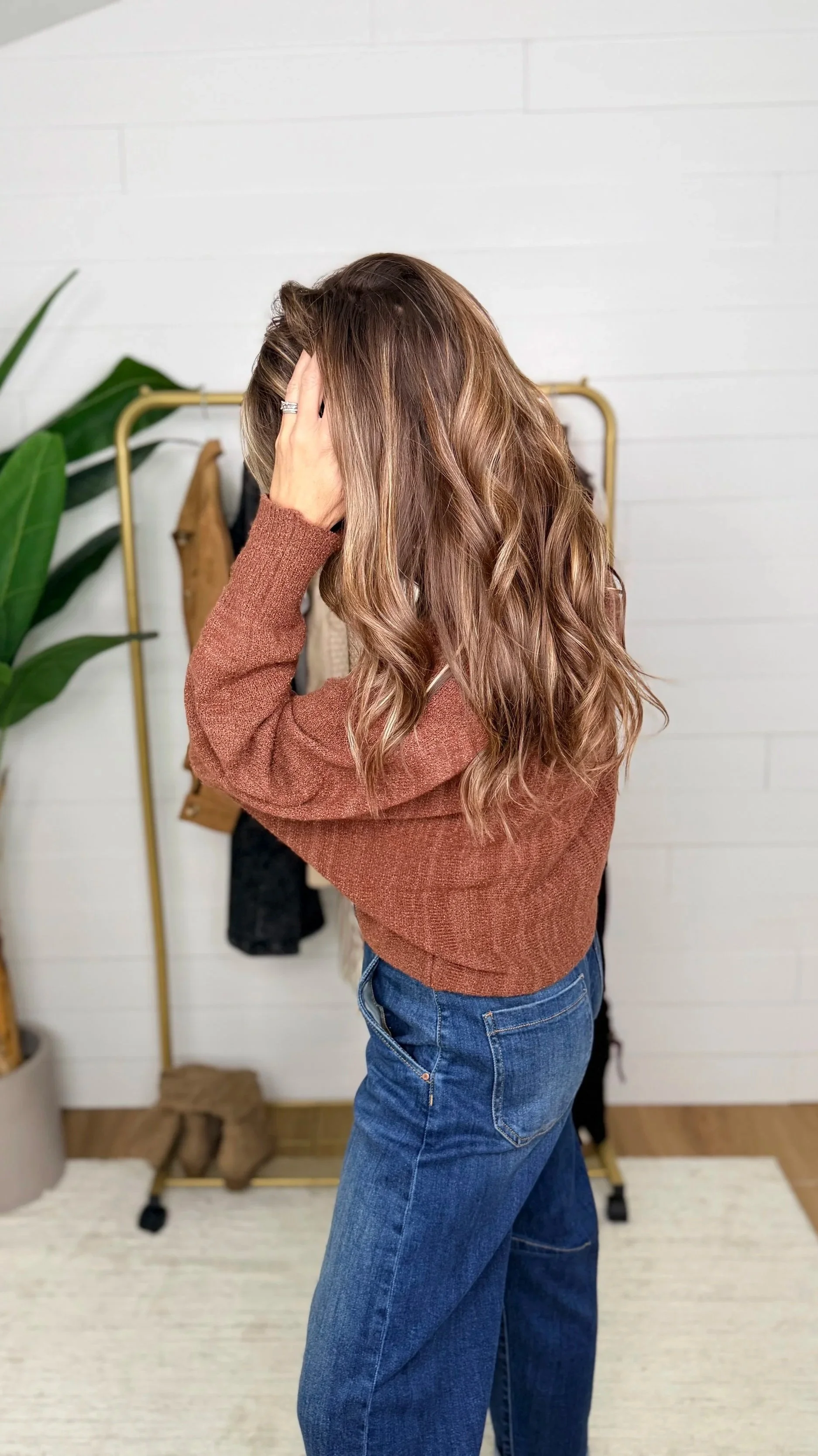 warm brown knit sweater side view paired with dark cuffed jeans