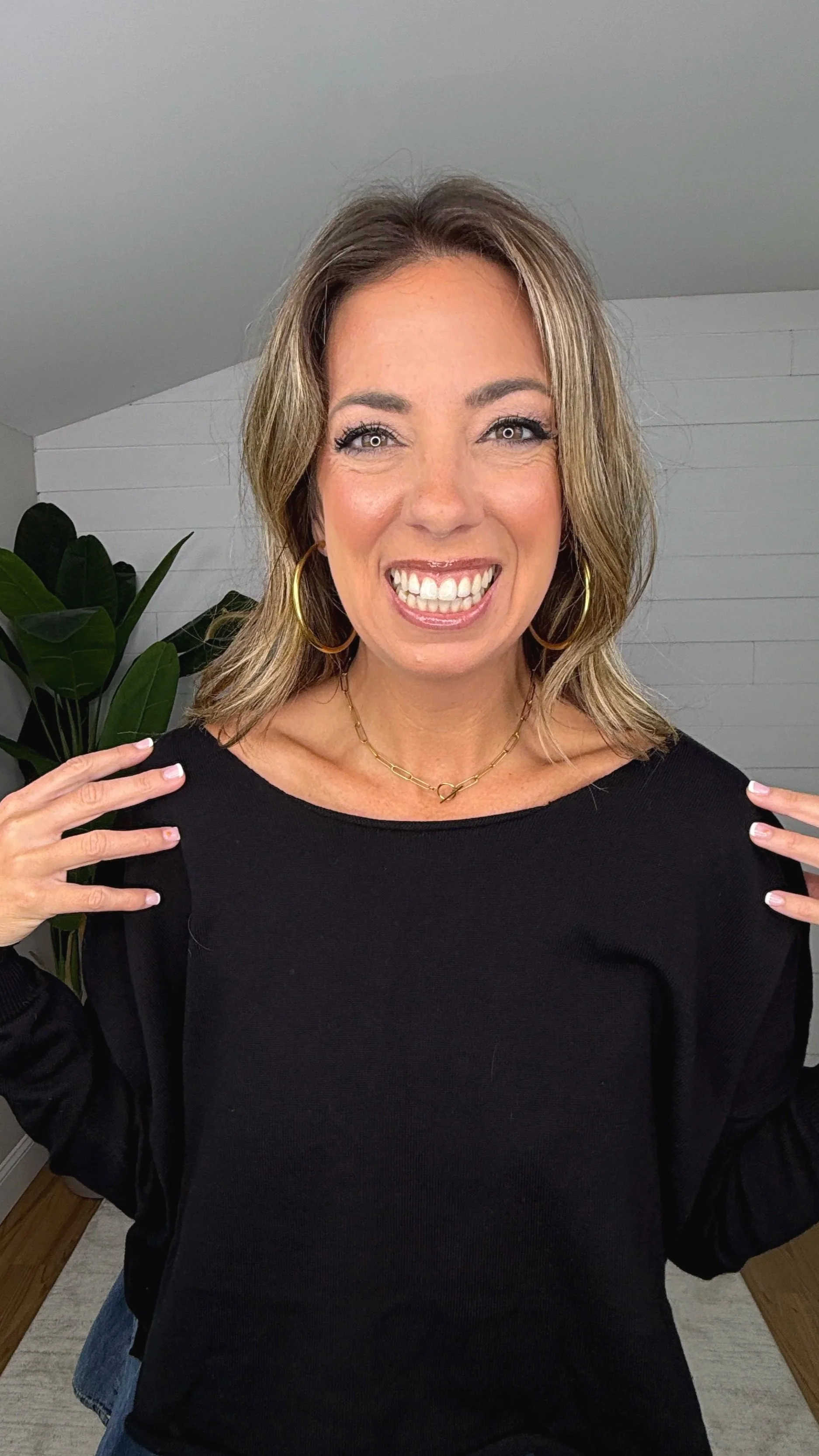 Close up of black knit crop top showing boat neckline and dropped shoulder design
