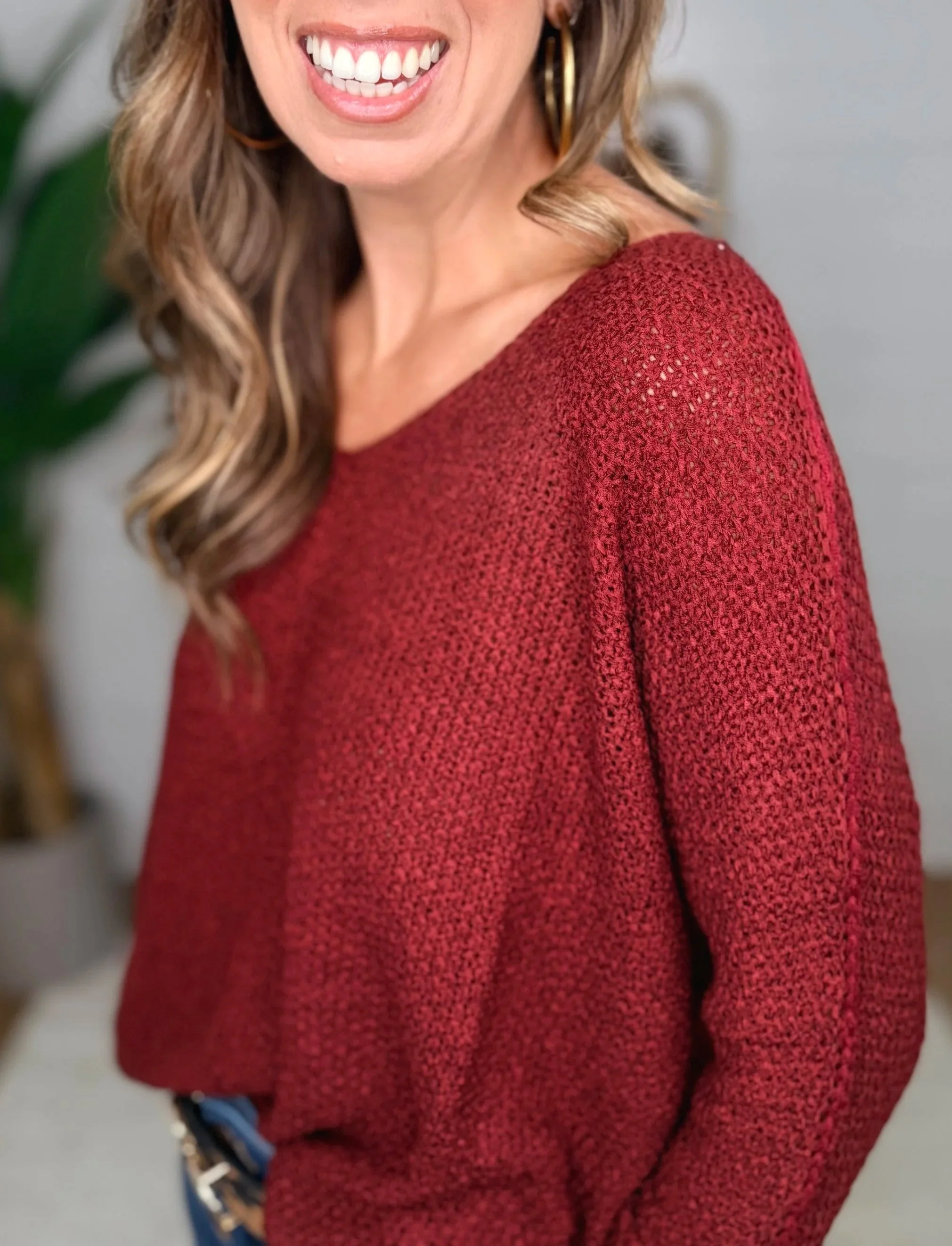 Close up of wine knit sweater fabric showing v-neckline and sleeve detail