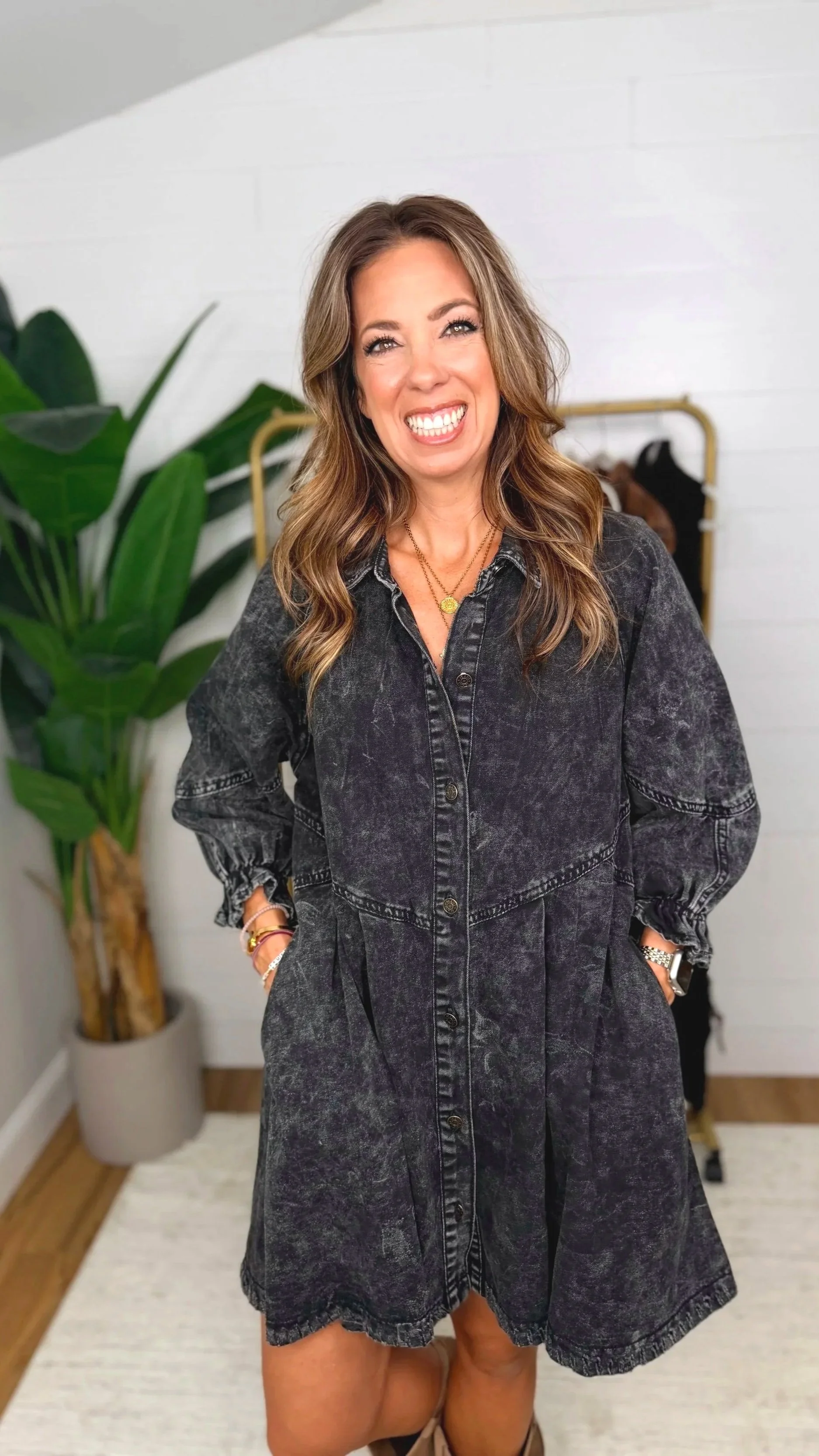 Black washed denim shirt dress with hands in pockets showing relaxed, flowy silhouette