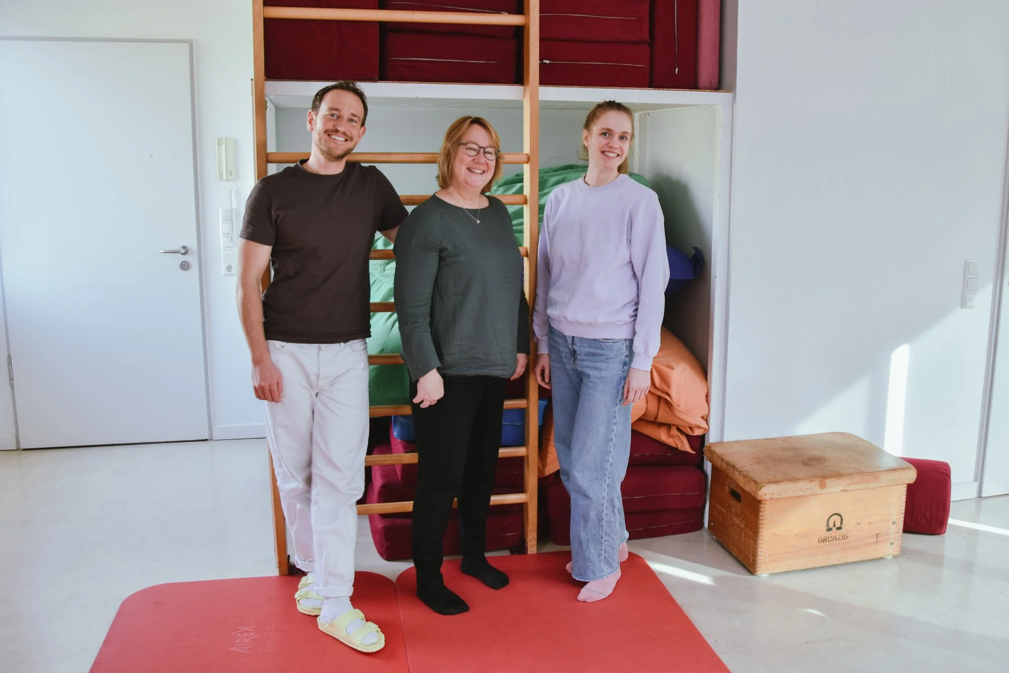 Drei Personen vor einer Sprossenwand