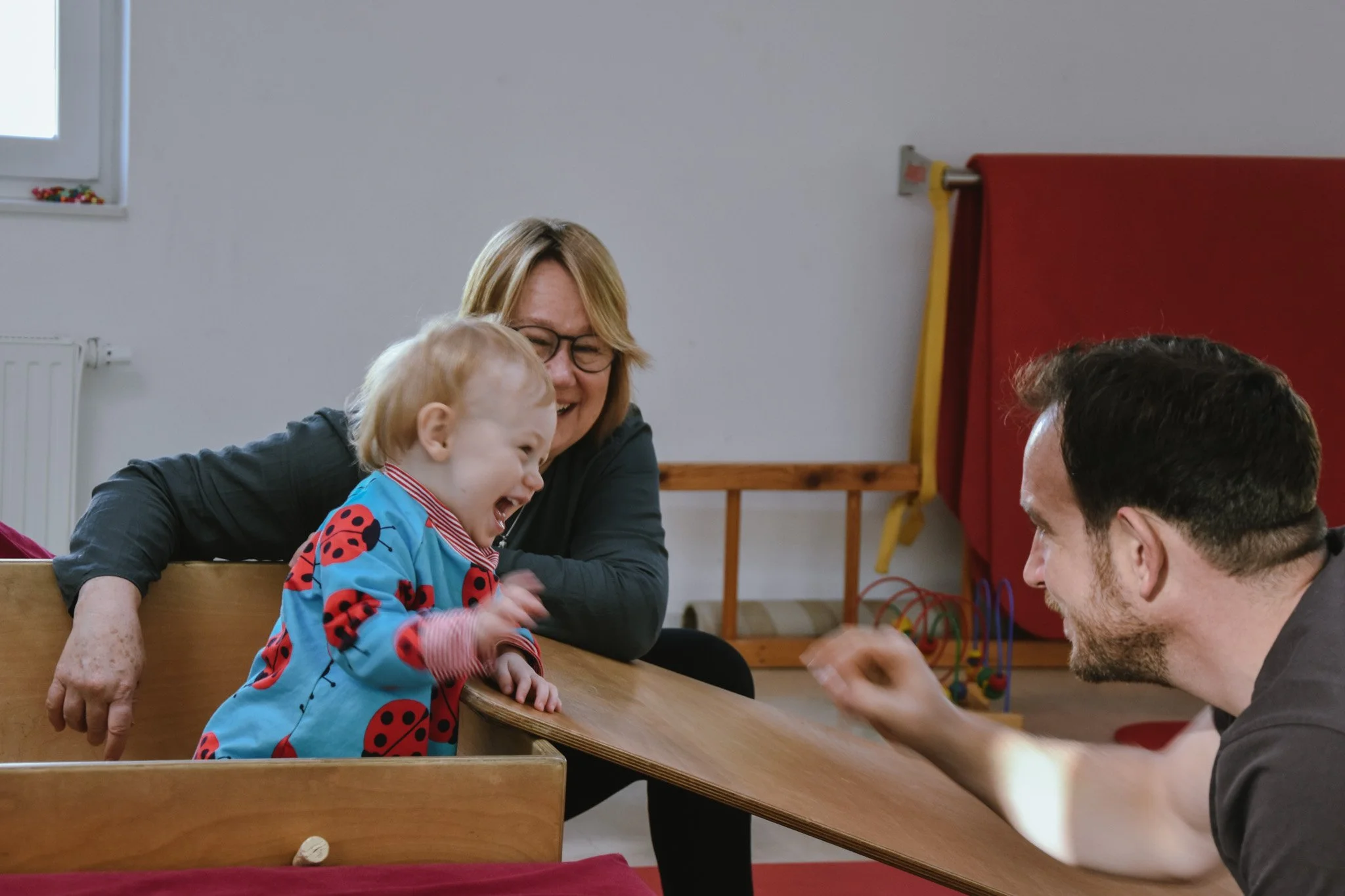 Kinderphysiotherapeut und Kinderphysiotherapeutinnen bei der Arbeit mit einem Kleinkind