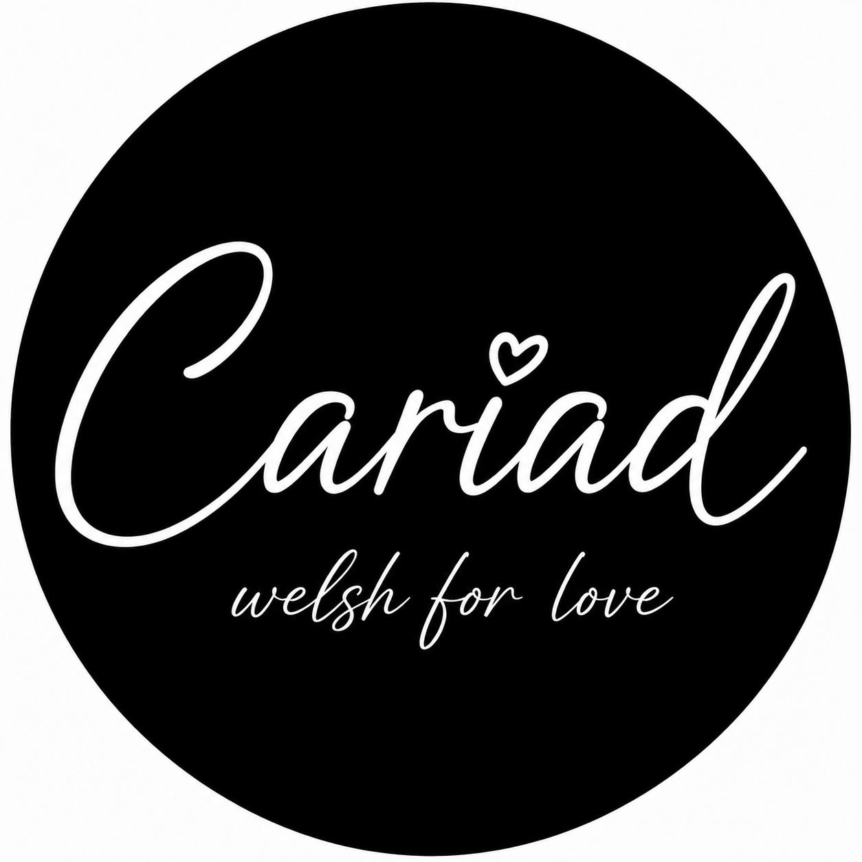 Black circular logo with white cursive text that reads "Câriad" with a small heart above the "i" and the tagline "welsh for love" below.