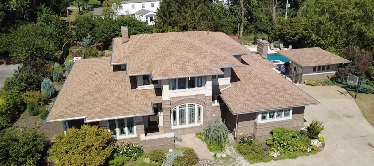 Aerial view of a residential house with a new shingle roof repair and maintenance by National Roofing St. Louis