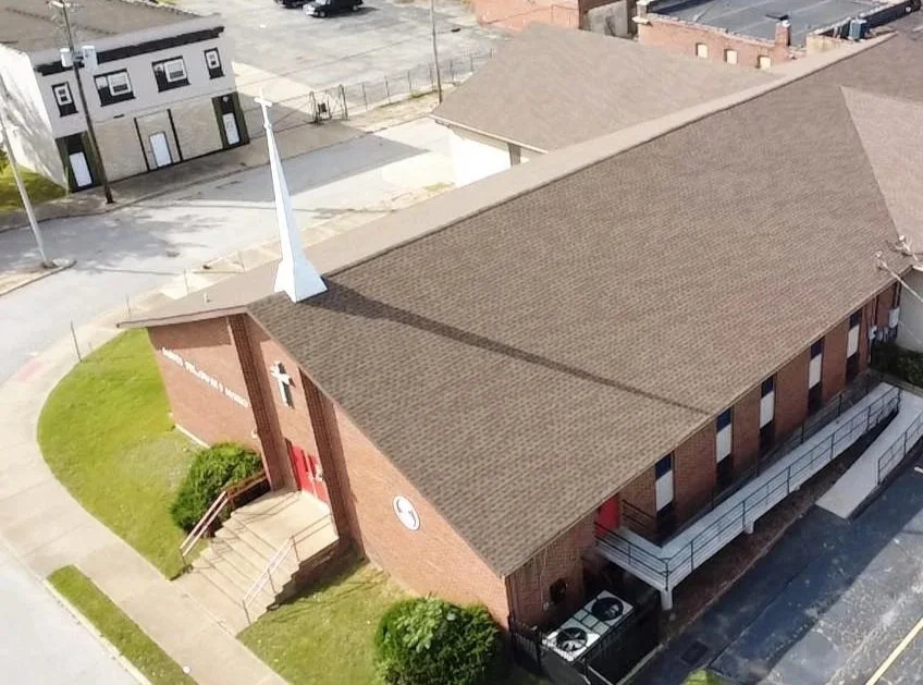 Bird's eye view of a brick church with a new shingle roof replacement by National Roofing St. Louis