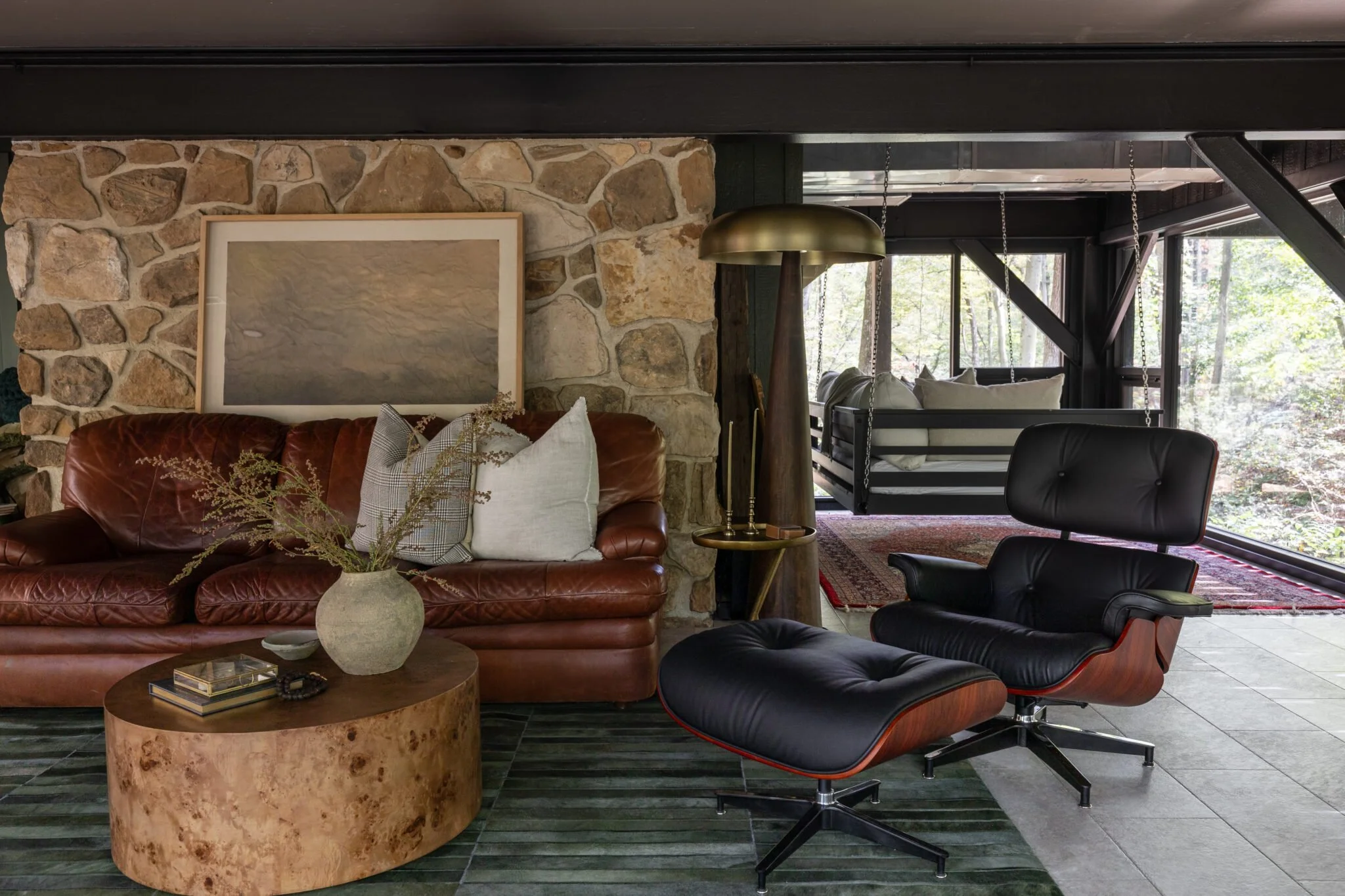 Transformed basement remodel for modern living by S. Flynn Design + Build showcasing a living room with modern leather furniture and gold accents