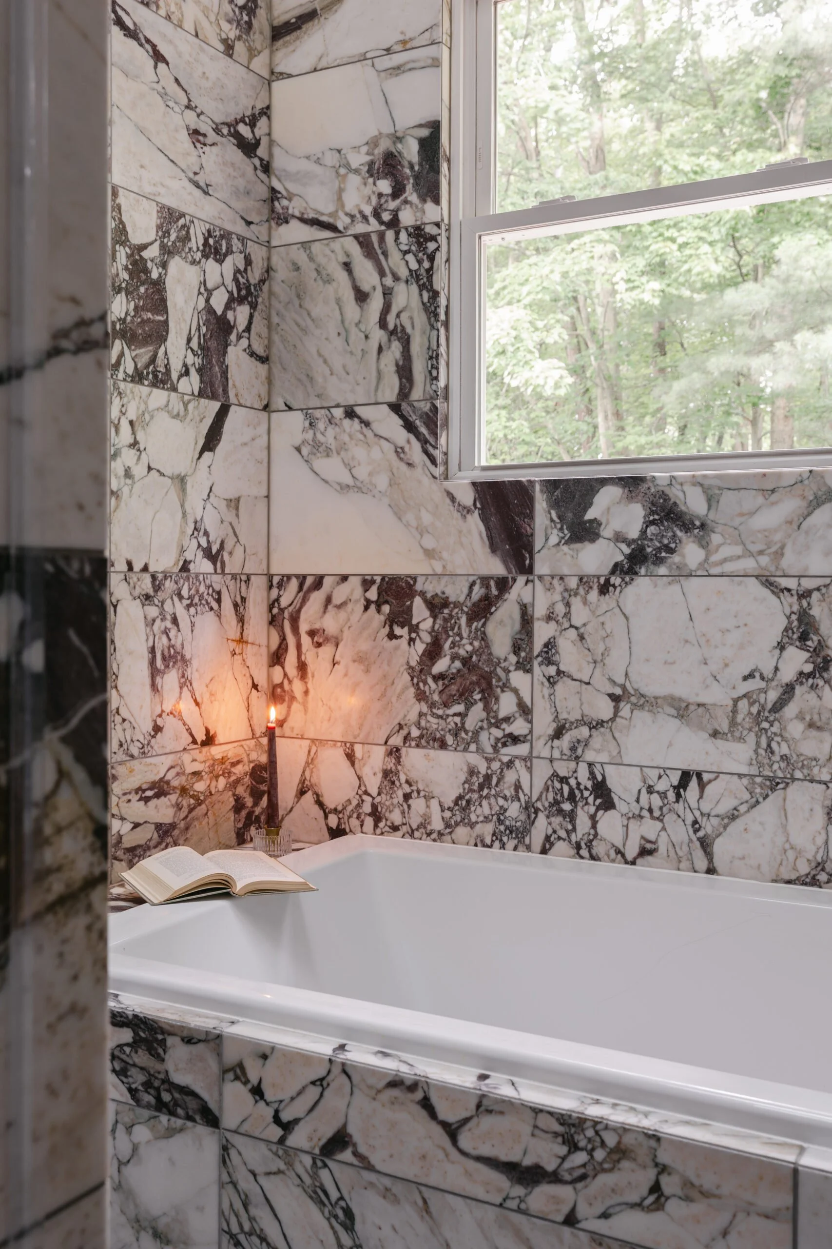 White and grey marbled tiling in bathroom shower and tub by S Flynn Design + Build