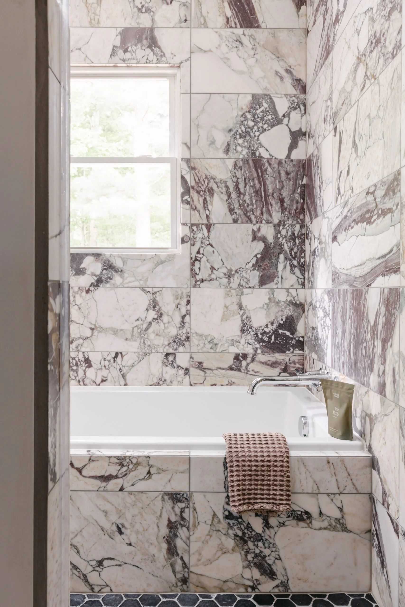 White and grey marbled tiling in bathroom shower and tub by S Flynn Design + Build