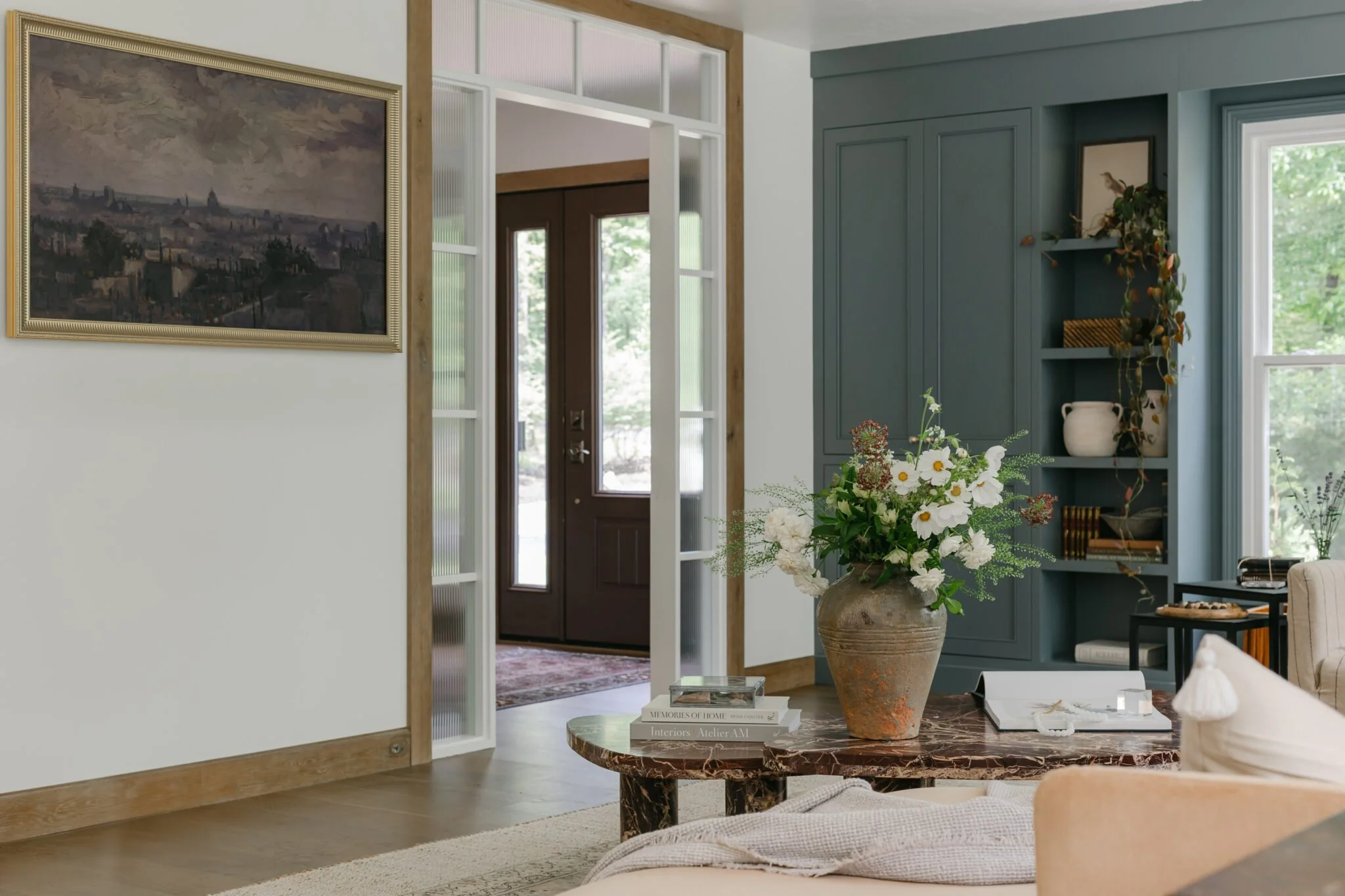 Blue built. in shelving and soft, cozy furniture and wooden lamp styling in living room remodel by S. FLynn Design + Build