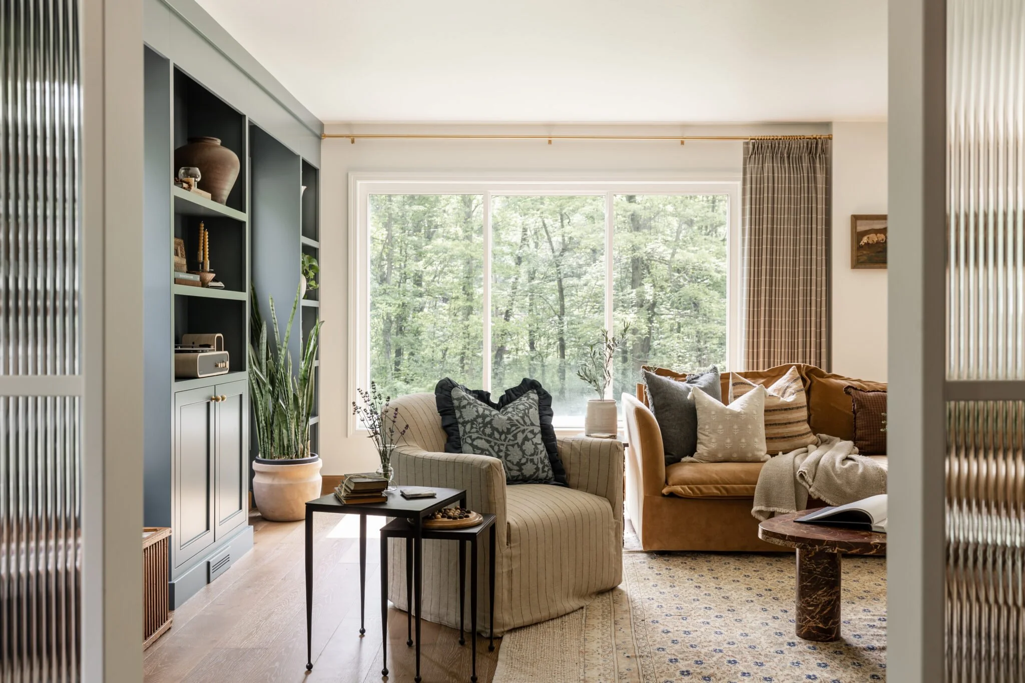 Leather sofa with assorted throw pillows and large textured vase in living room remodel and styling by S. Flynn Design + Build