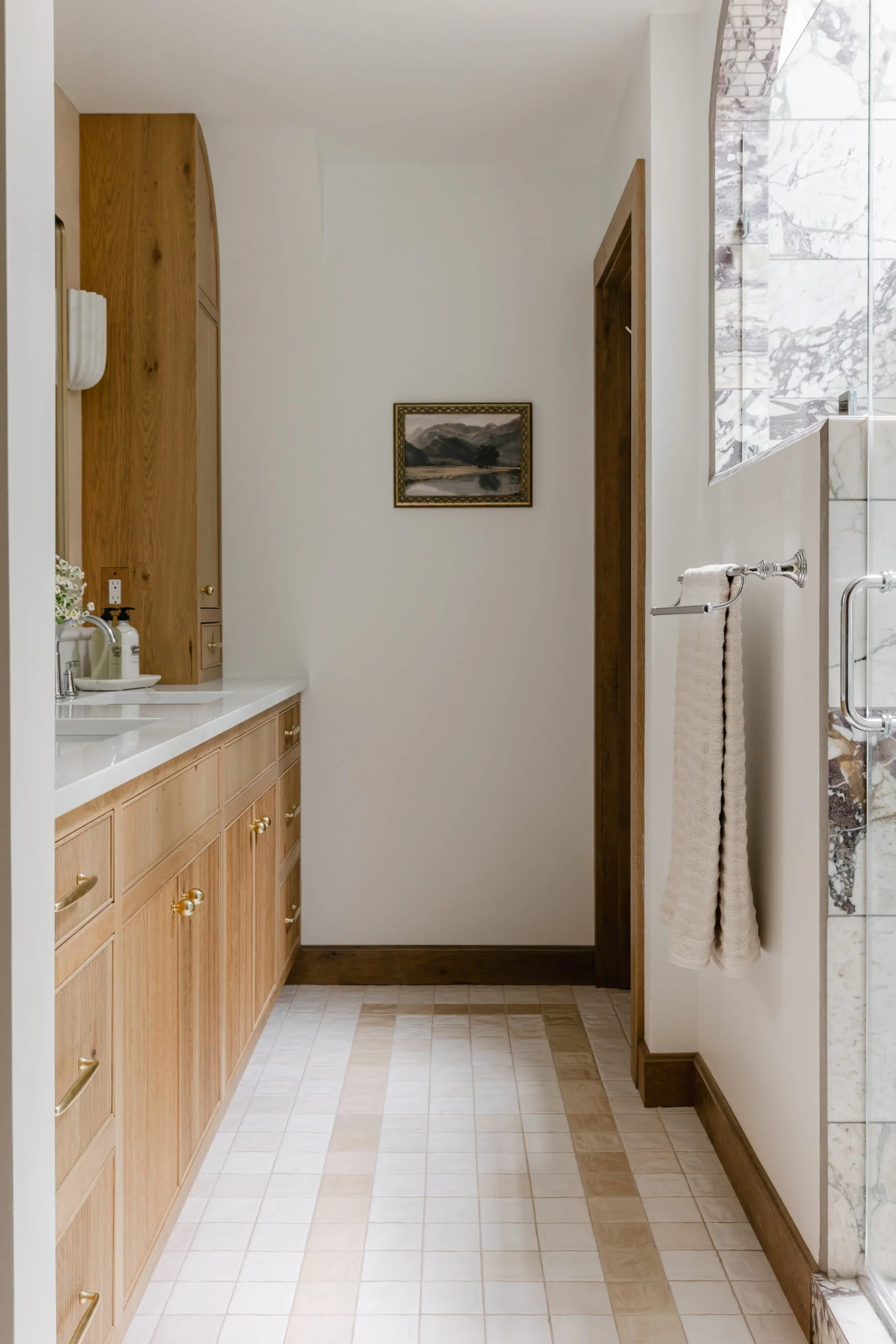 Warm brown cabinets with golden hardware in master bathroom remodel by S. Flynn Design + Build