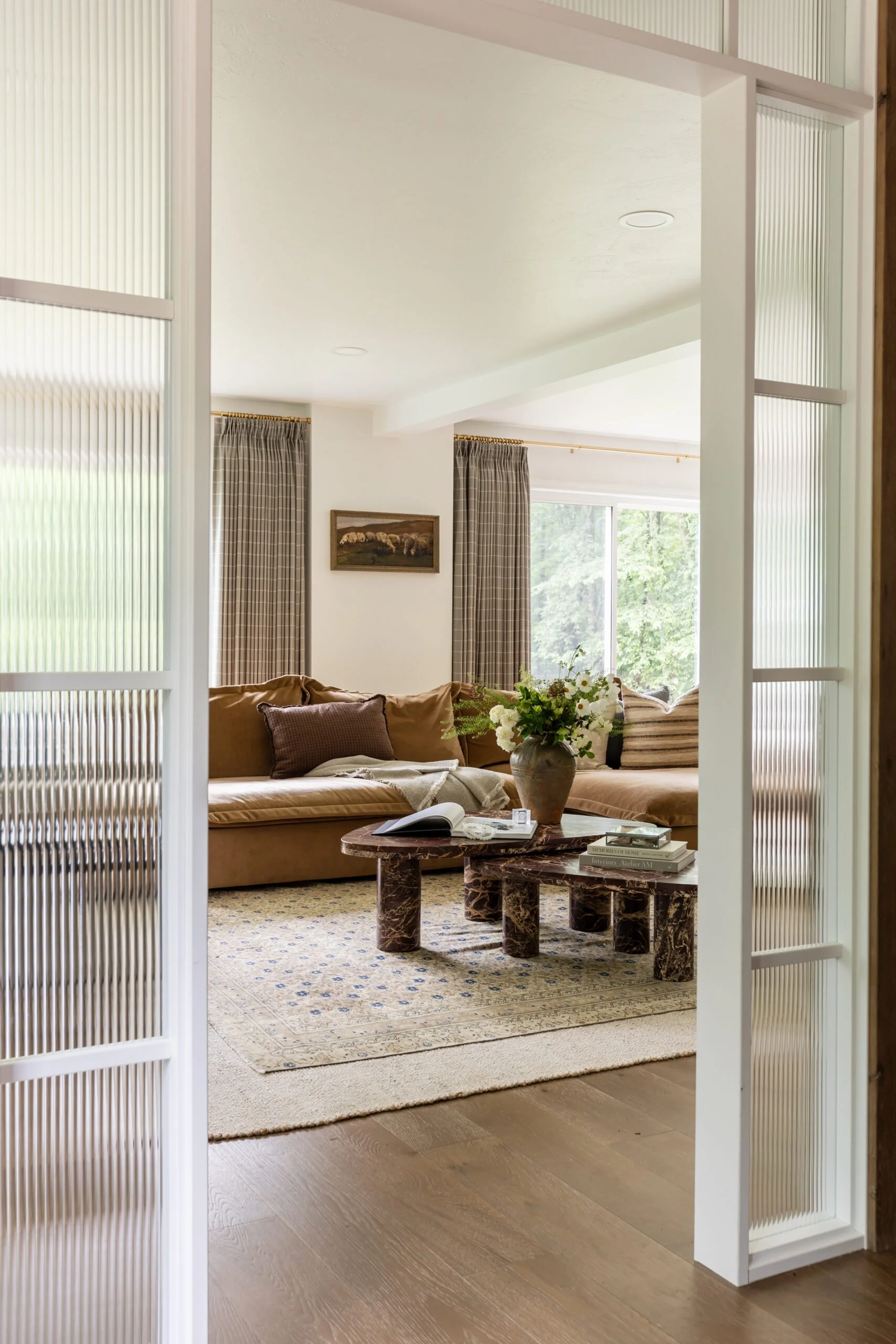 Leather sofa with assorted throw pillows and large textured vase in living room remodel and styling by S. Flynn Design + Build