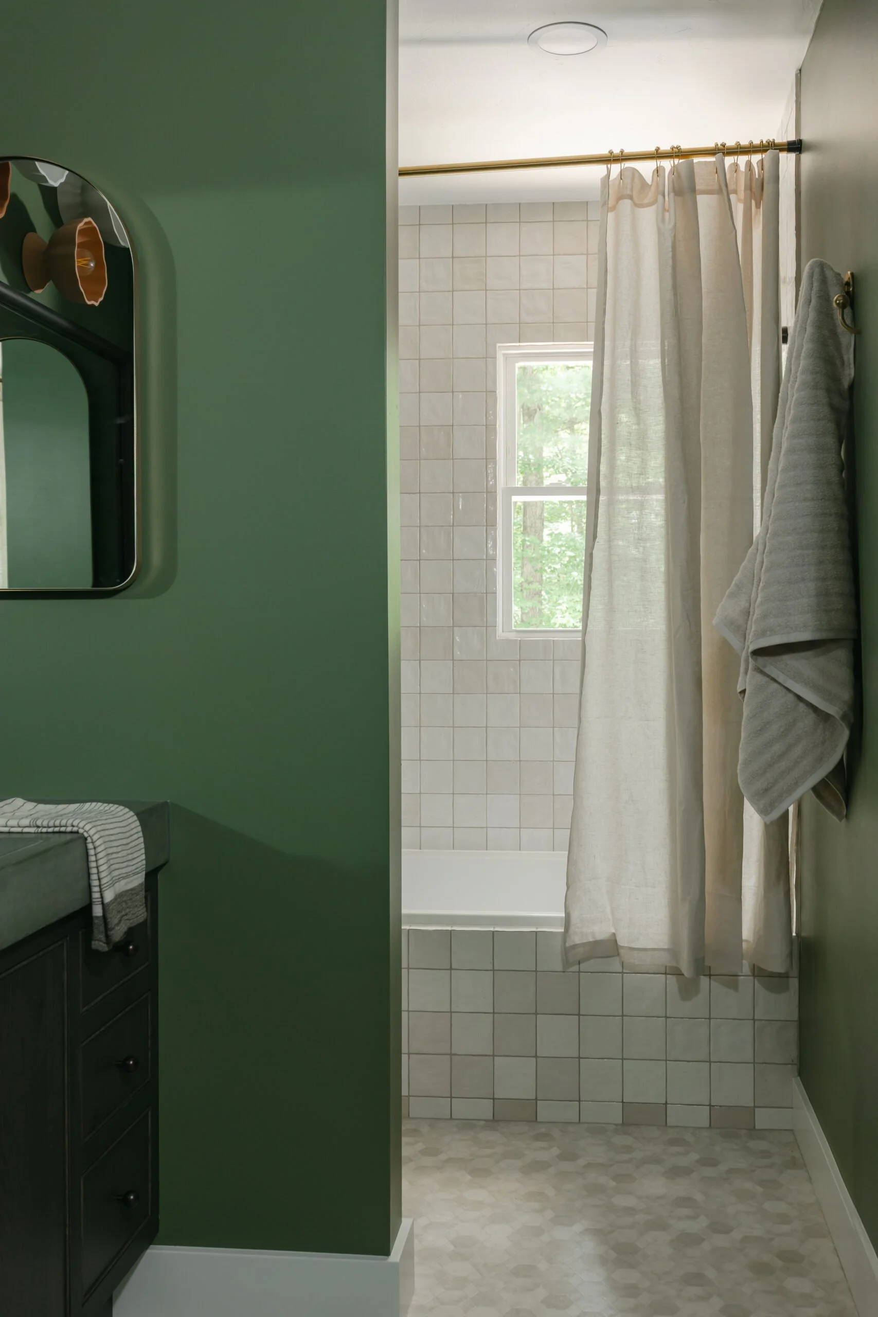 Modern beige bathroom tiling and sage green walls in bathroom remodel by S. Flynn Design + Build