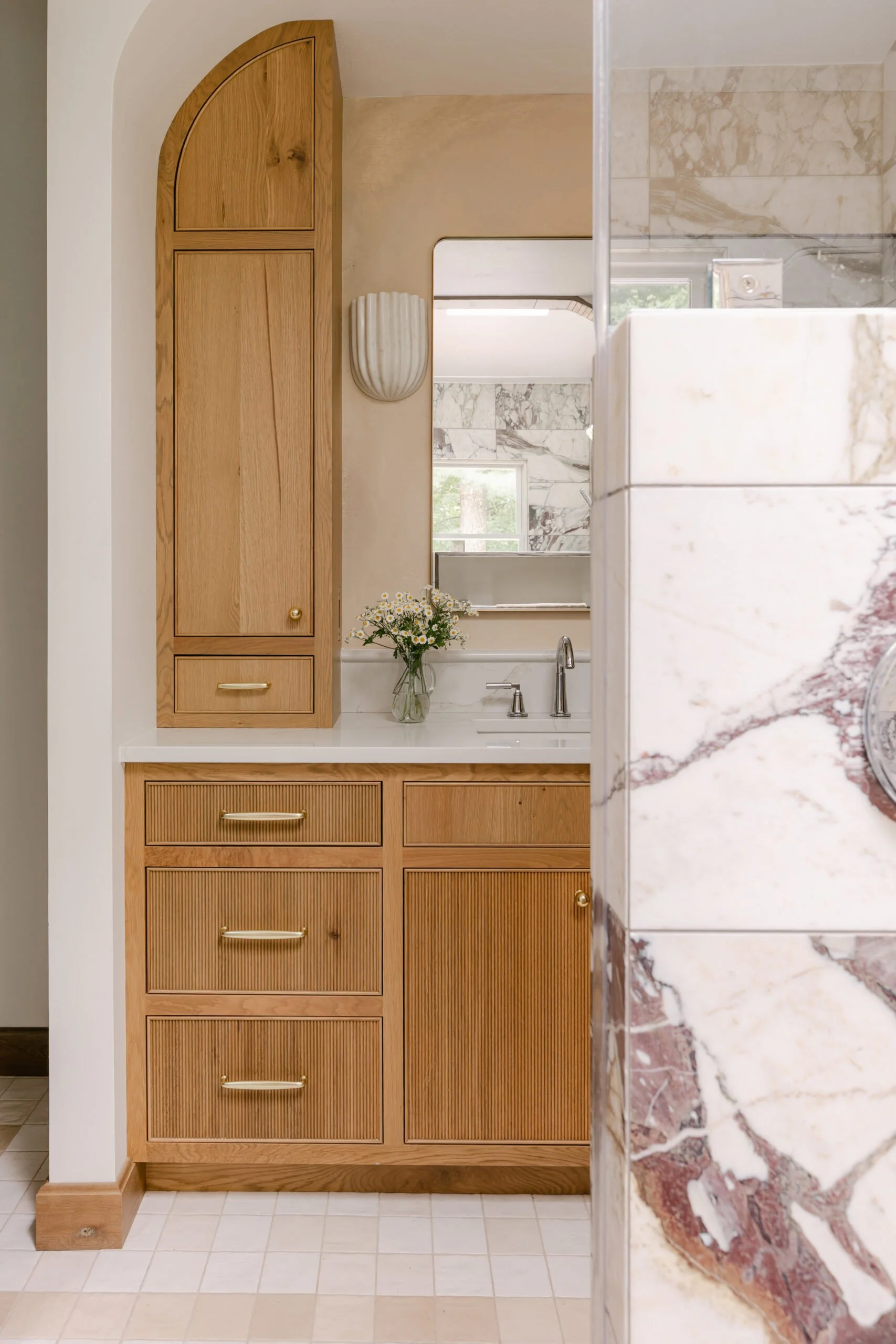 Warm brown cabinets with golden hardware in master bathroom remodel by S. Flynn Design + Build