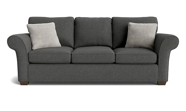 Gray three-seat fabric sofa with two light-colored pillows and rolled arms.