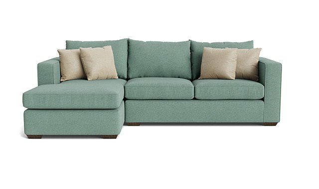 A mint green sectional sofa with beige throw pillows