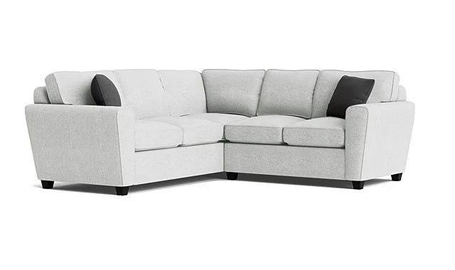Light gray sectional sofa with three black throw pillows against a white background.