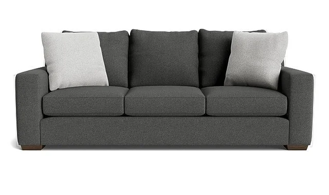 Gray fabric sofa with three seat cushions, three back cushions, and three throw pillows, two light gray and one dark gray.