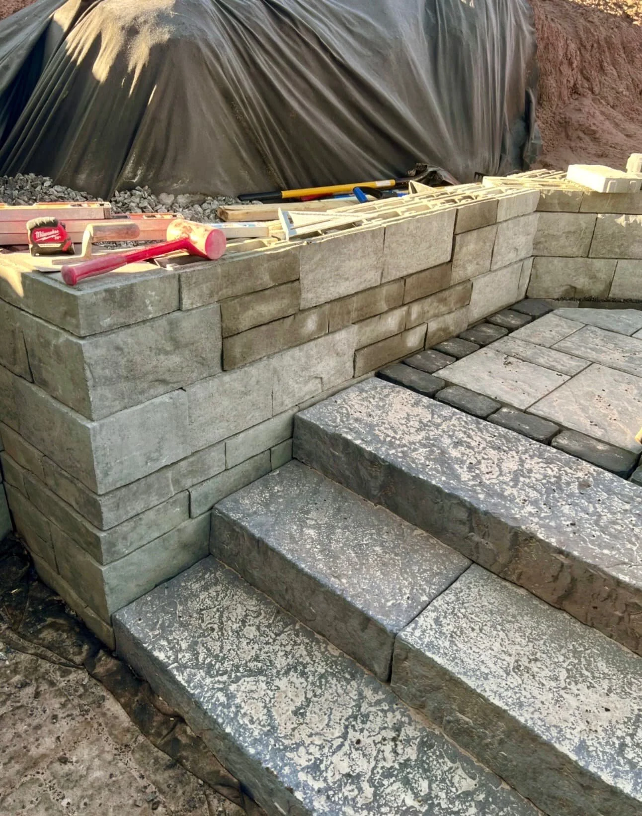 Curved retaining wall and paver patio installation at a Skaneateles, NY home with a clean multi-level hardscape layout.