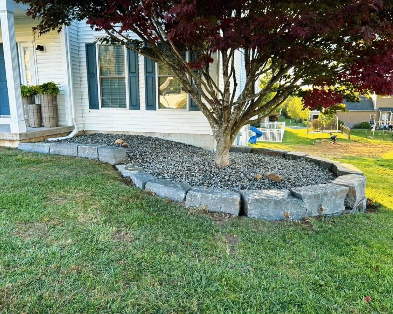 Side yard landscape refresh at a Central New York home with fresh mulch, shaped beds, and clean lawn edges.