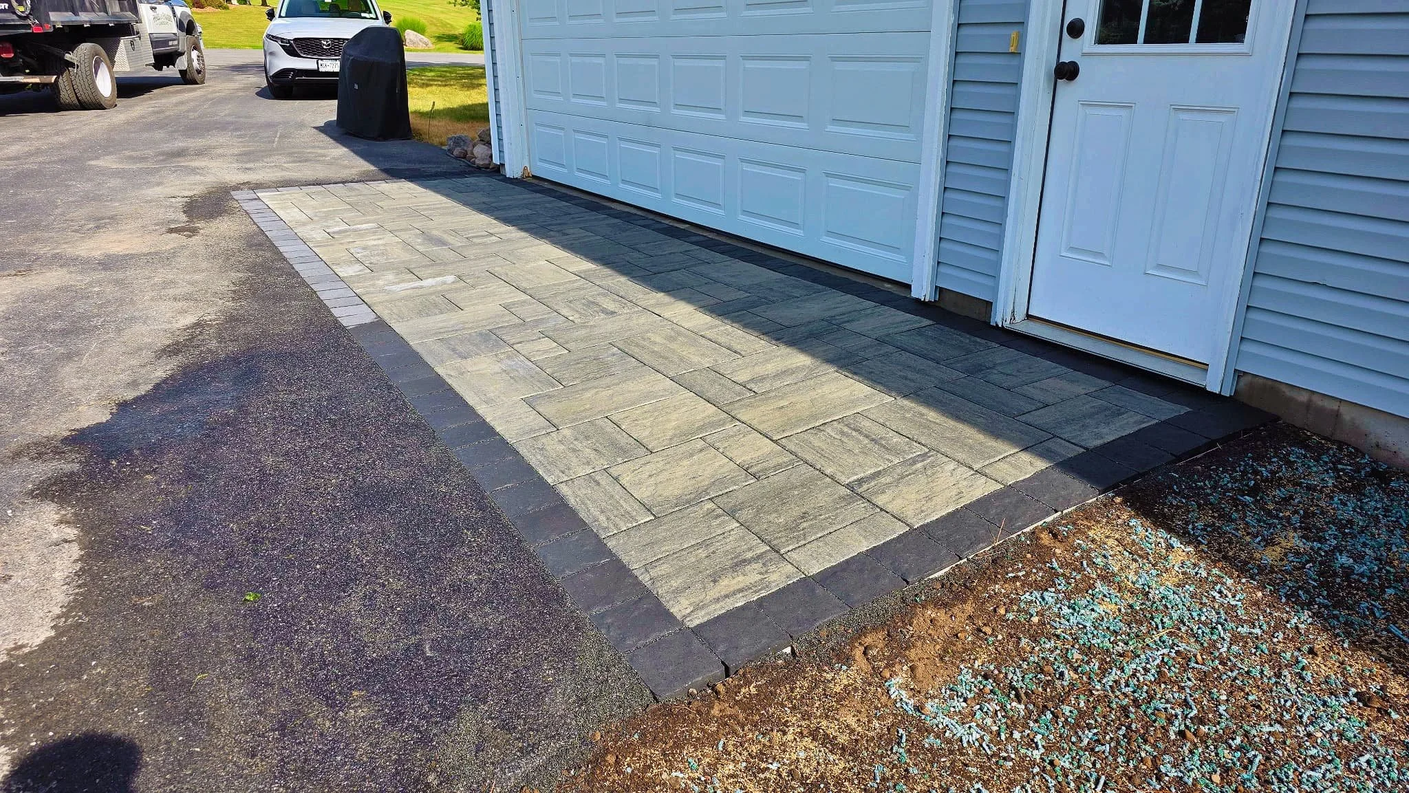 Finished concrete driveway section installed alongside a garage in Central New York.