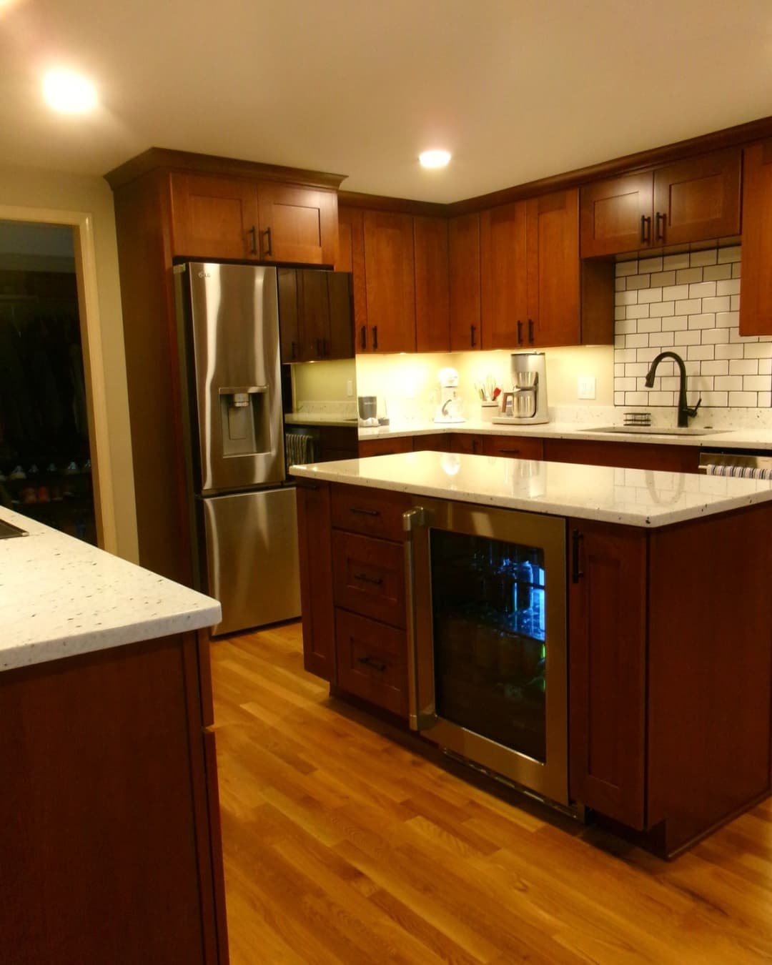 Kitchen sink area in a Fayetteville, NY remodel with granite countertops, wood cabinetry, and tiled backsplash.