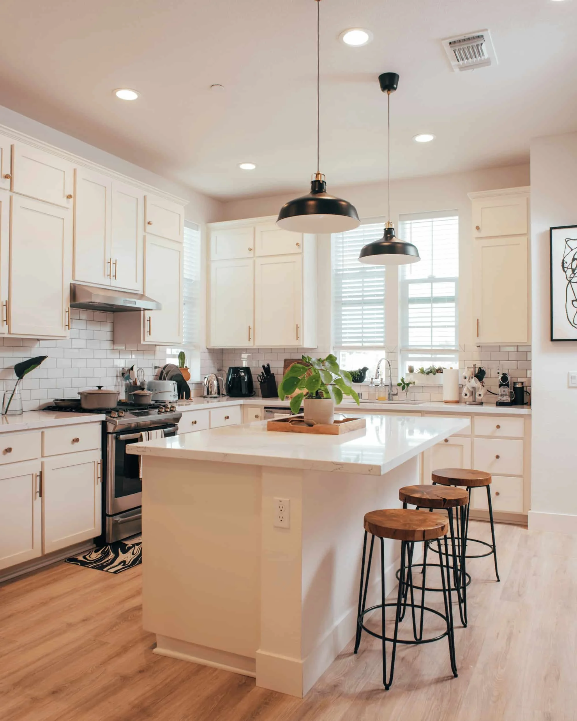Bright modern kitchen renovation with white cabinetry and island seating