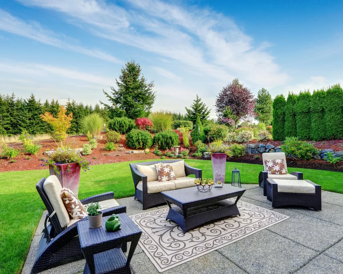 Landscape framing inspiration with an outdoor seating area framed by lawn, planting beds, and layered garden borders.
