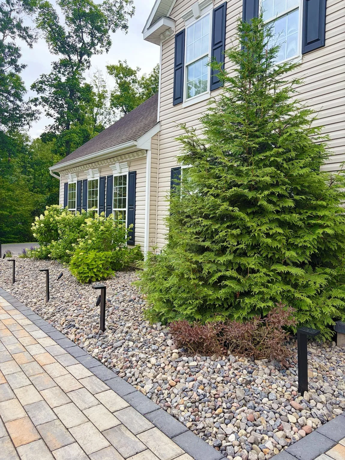 Square paver patio with contrasting border creating a defined outdoor space in Central NY.