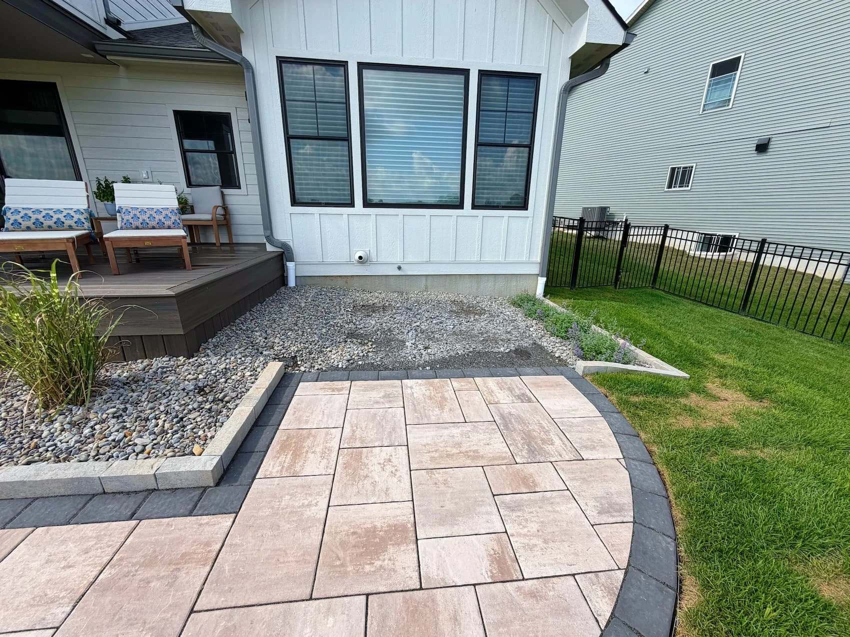 Finished backyard landscape with paver patio and green lawn in Central NY 