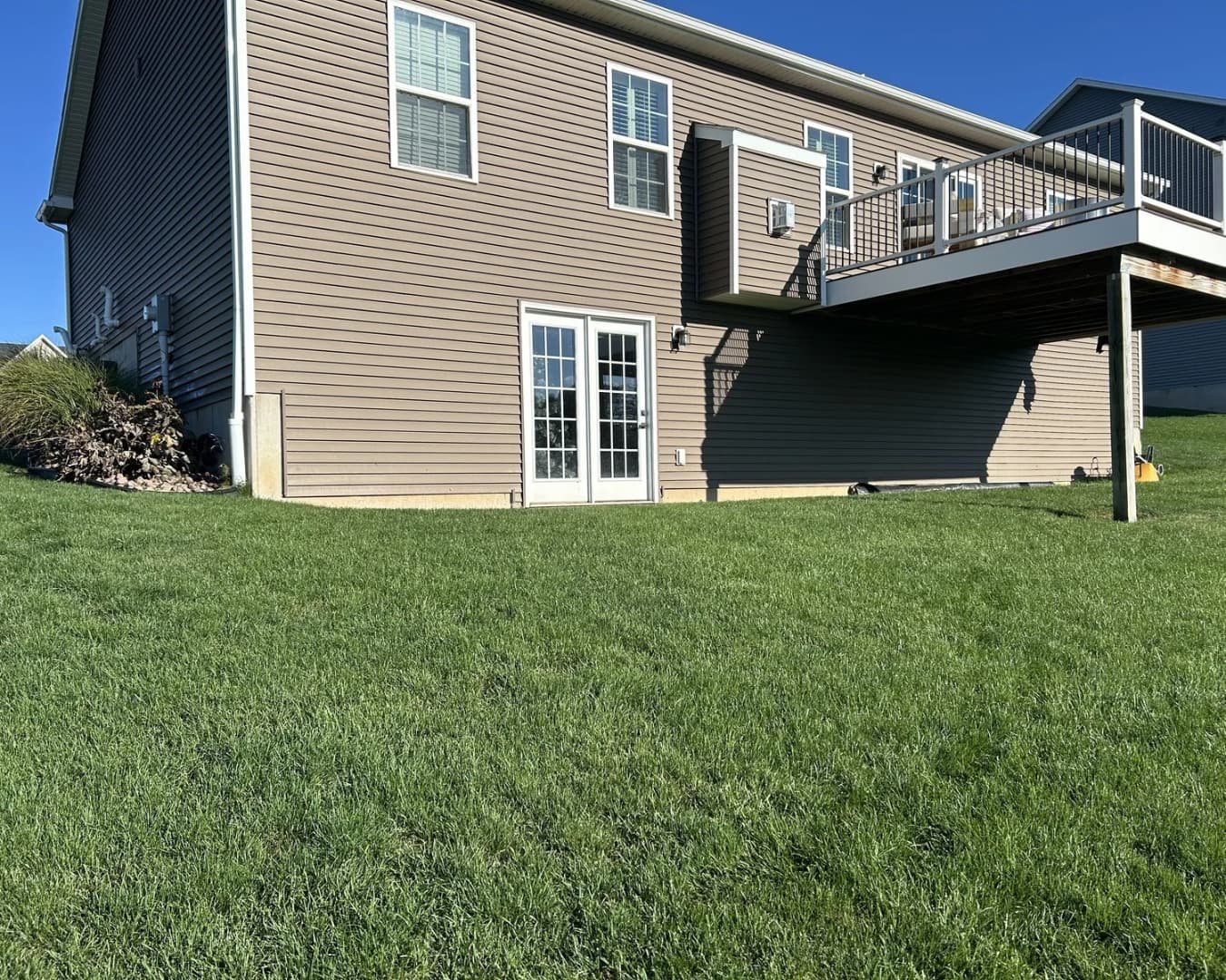 Backyard patio connection near deck steps at a Central New York outdoor living project.
