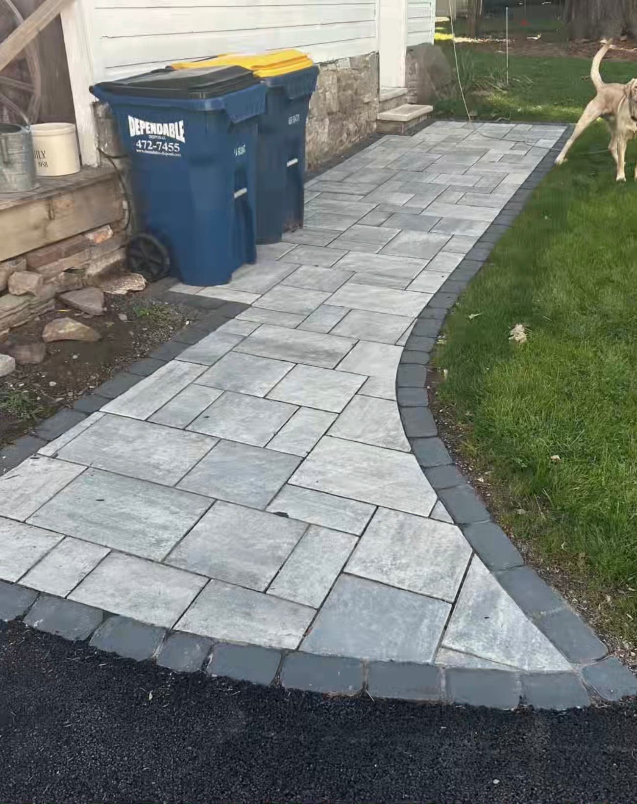 Curved front paver walkway at a Central New York home with dark border detail and a smooth transition to the entry.