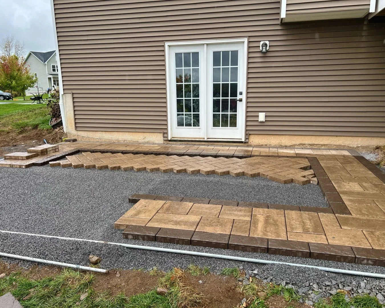 Large paver patio installation in progress by Pines and Pavers in Lysander, New York.
