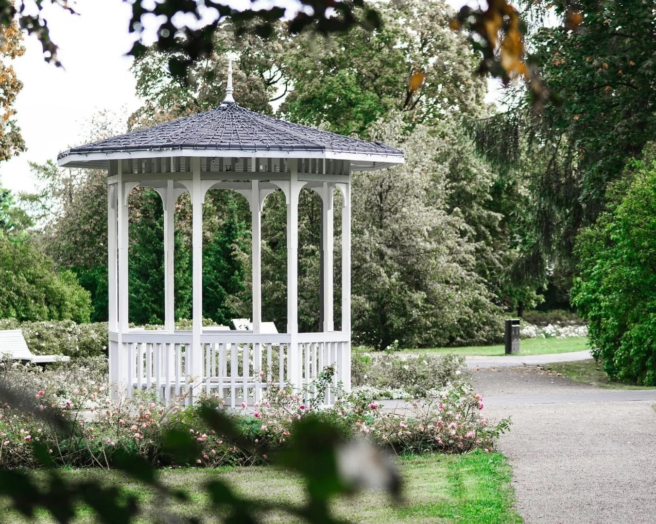 Carpentry inspiration with a glass greenhouse structure surrounded by flowering garden beds.