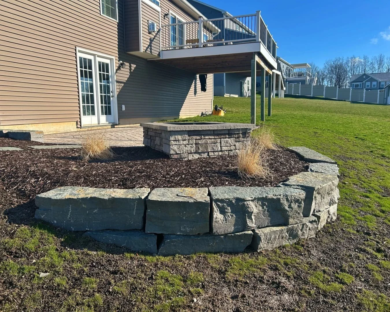 Rear yard hardscape overview completed by Pines and Pavers in Lysander, New York.