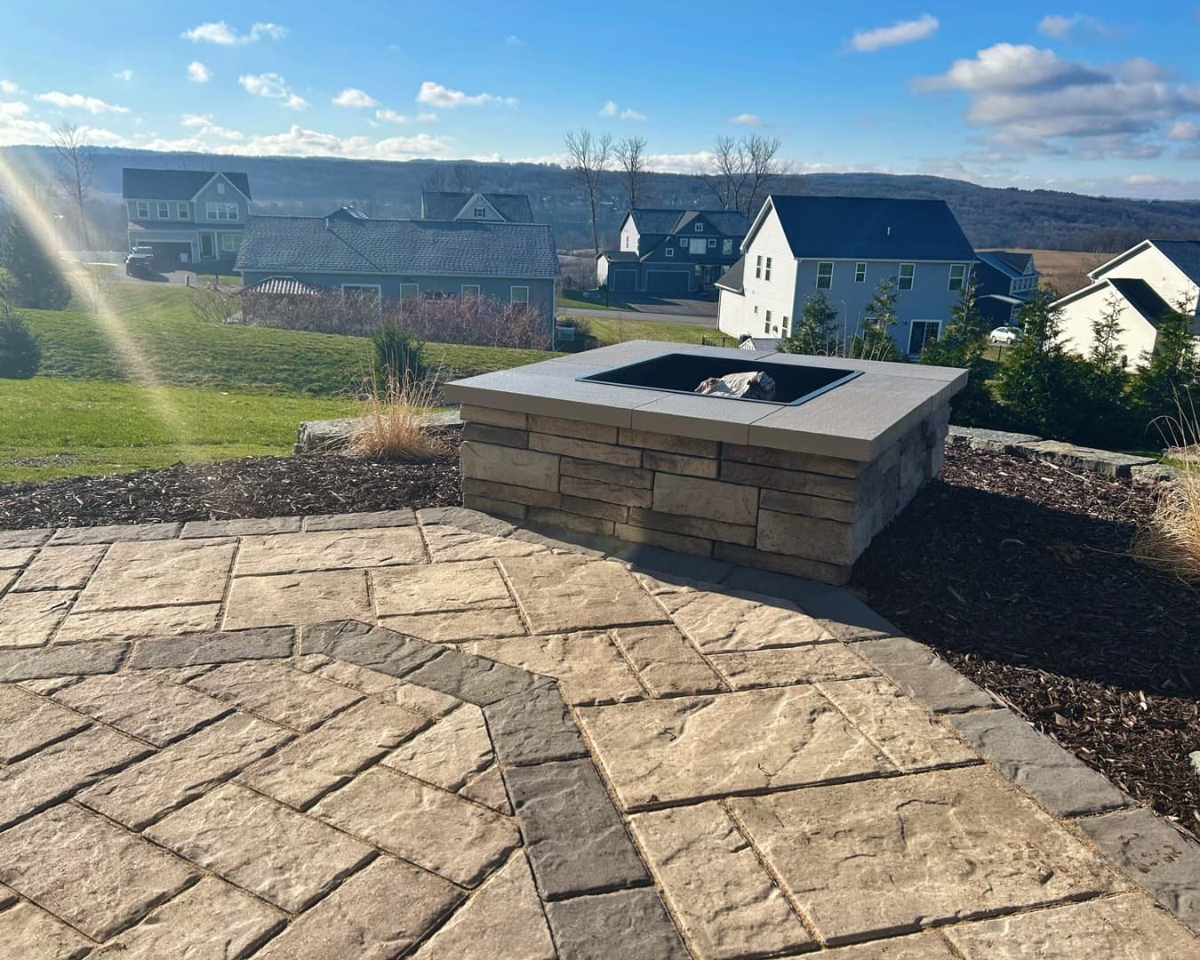 Raised seating wall and patio overview completed by Pines and Pavers in Lysander, New York.