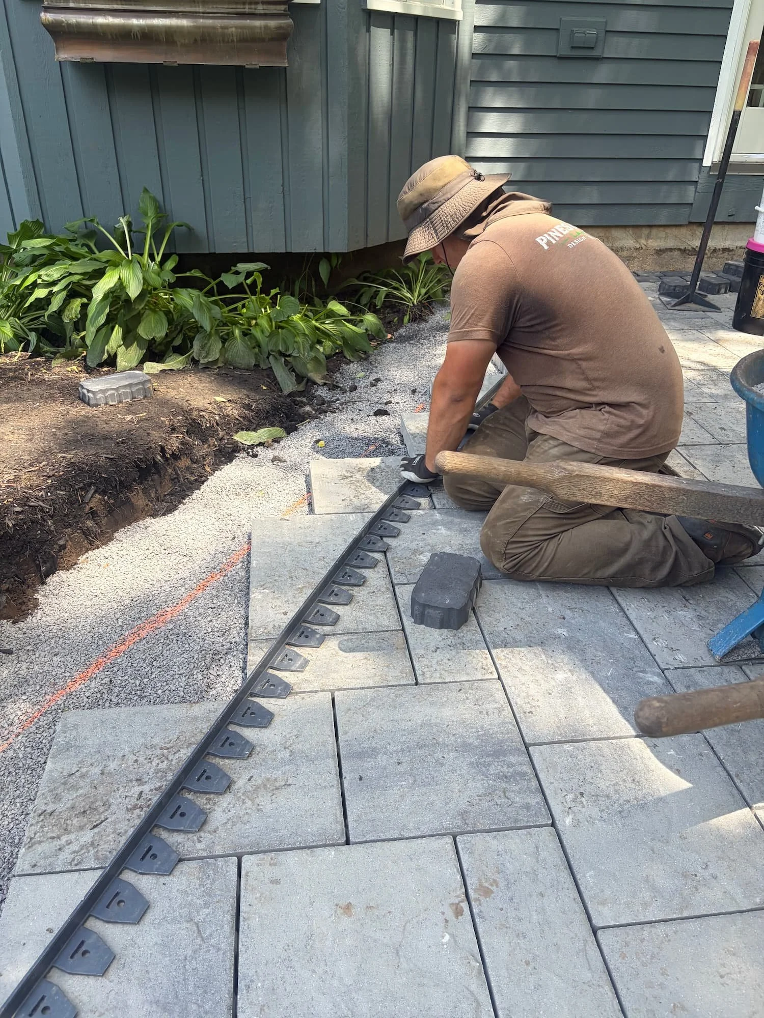 Pines and Pavers hardscape crew working together on a custom residential patio installation in Central New York.