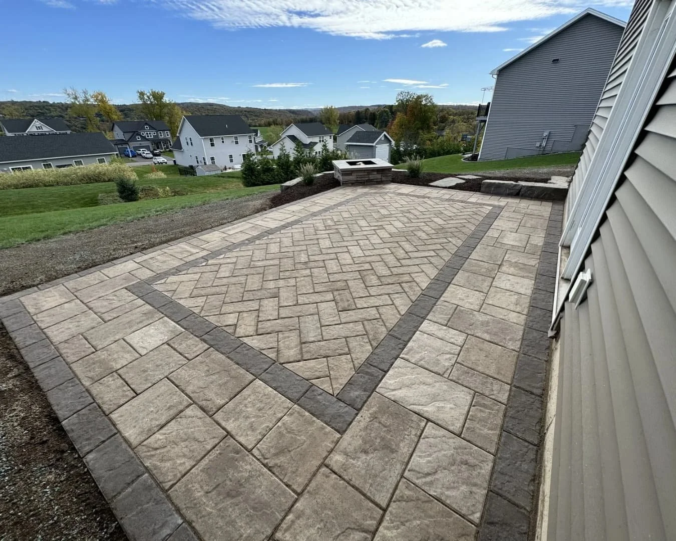 Fresh landscape bed with tree ring edging and mulch detail at a hardscape project in Central New York.