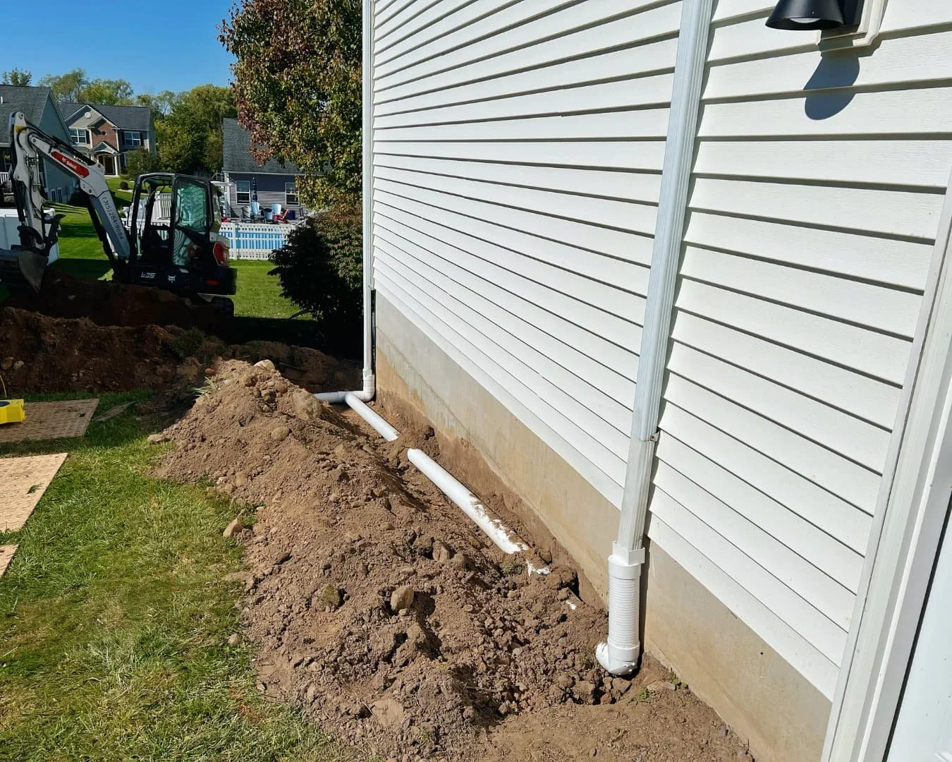 Side yard before grading and landscape work by Pines and Pavers in Lysander, New York.