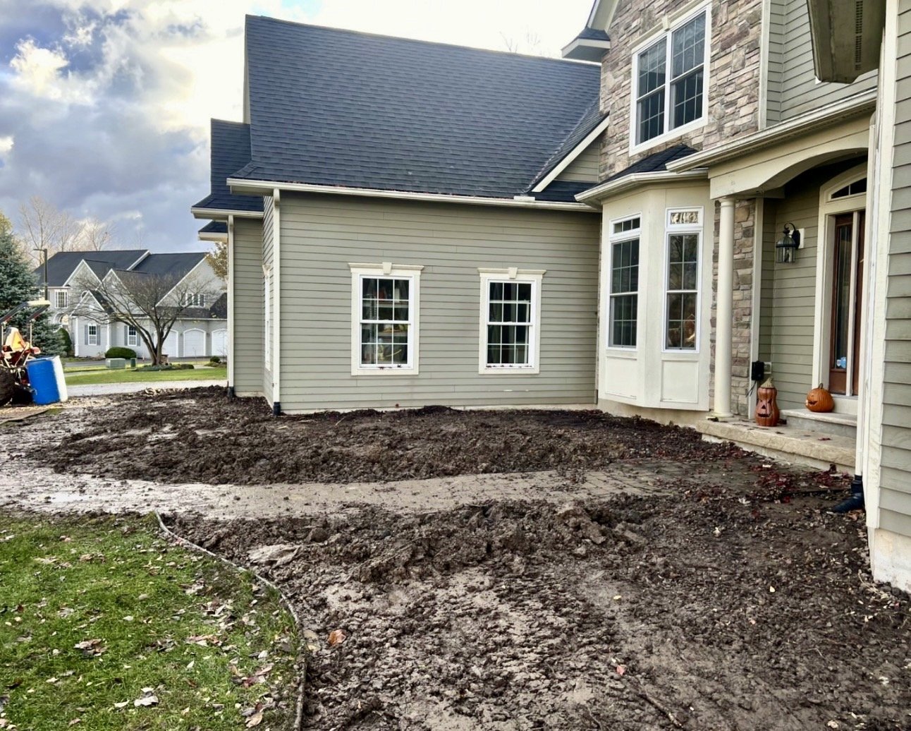 Curved front landscape bed preparation at a Cazenovia, NY home with fresh soil shaping and lawn transition.