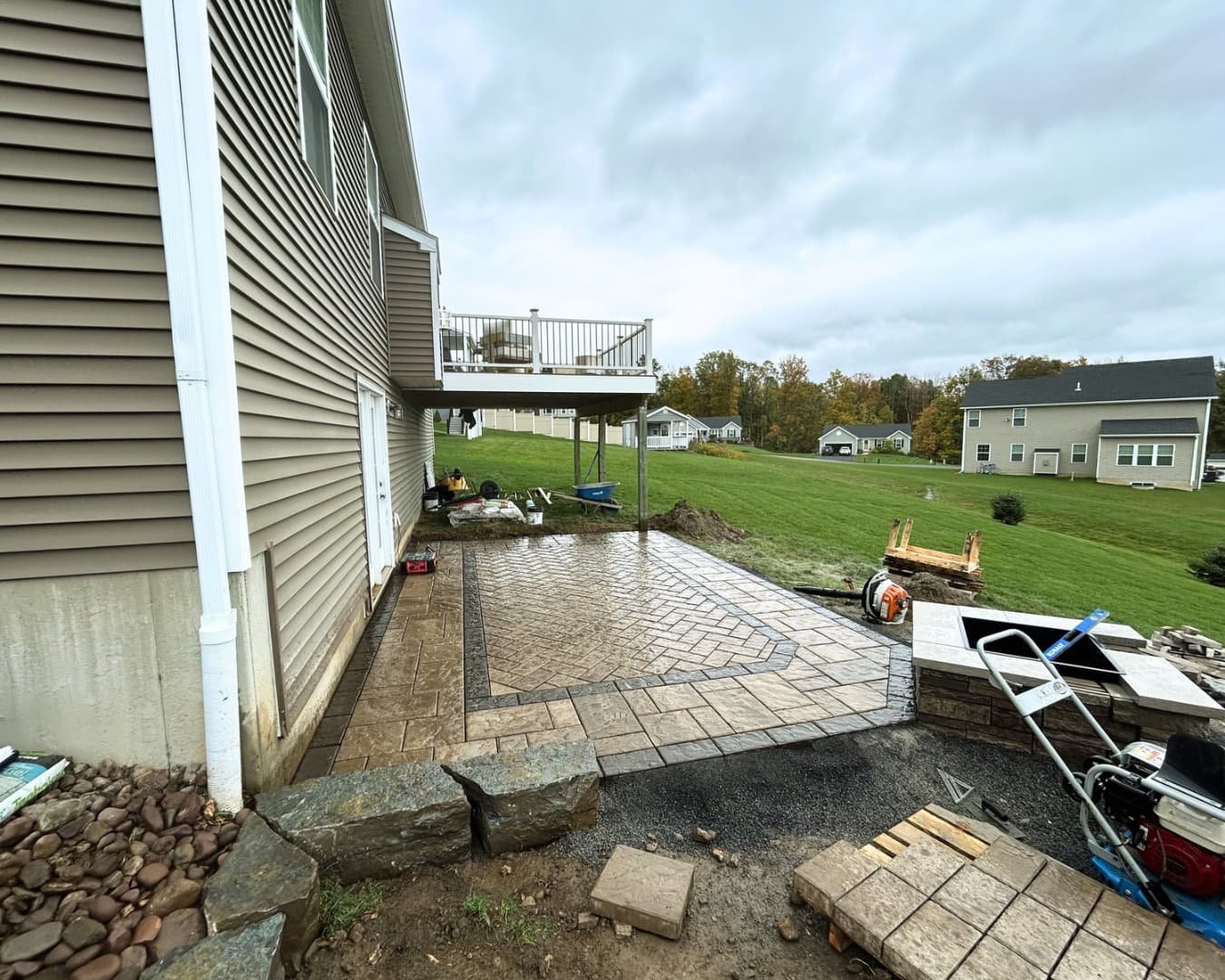 Backyard hardscape construction in progress with patio base preparation at a Central New York home.