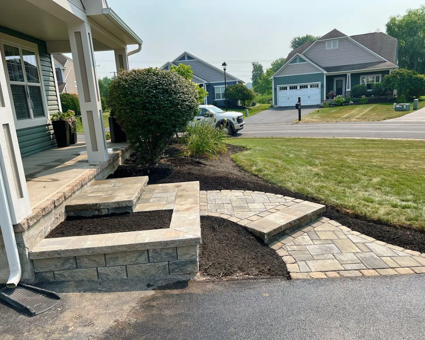 Paver entry walkway with curved bed edge completed by Pines and Pavers in Manlius, New York.