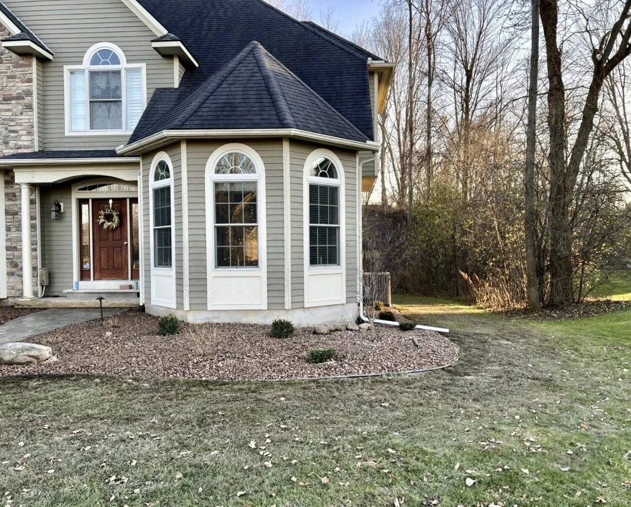Front planting bed preparation at an Upstate New York home with paver edging and newly shaped soil.