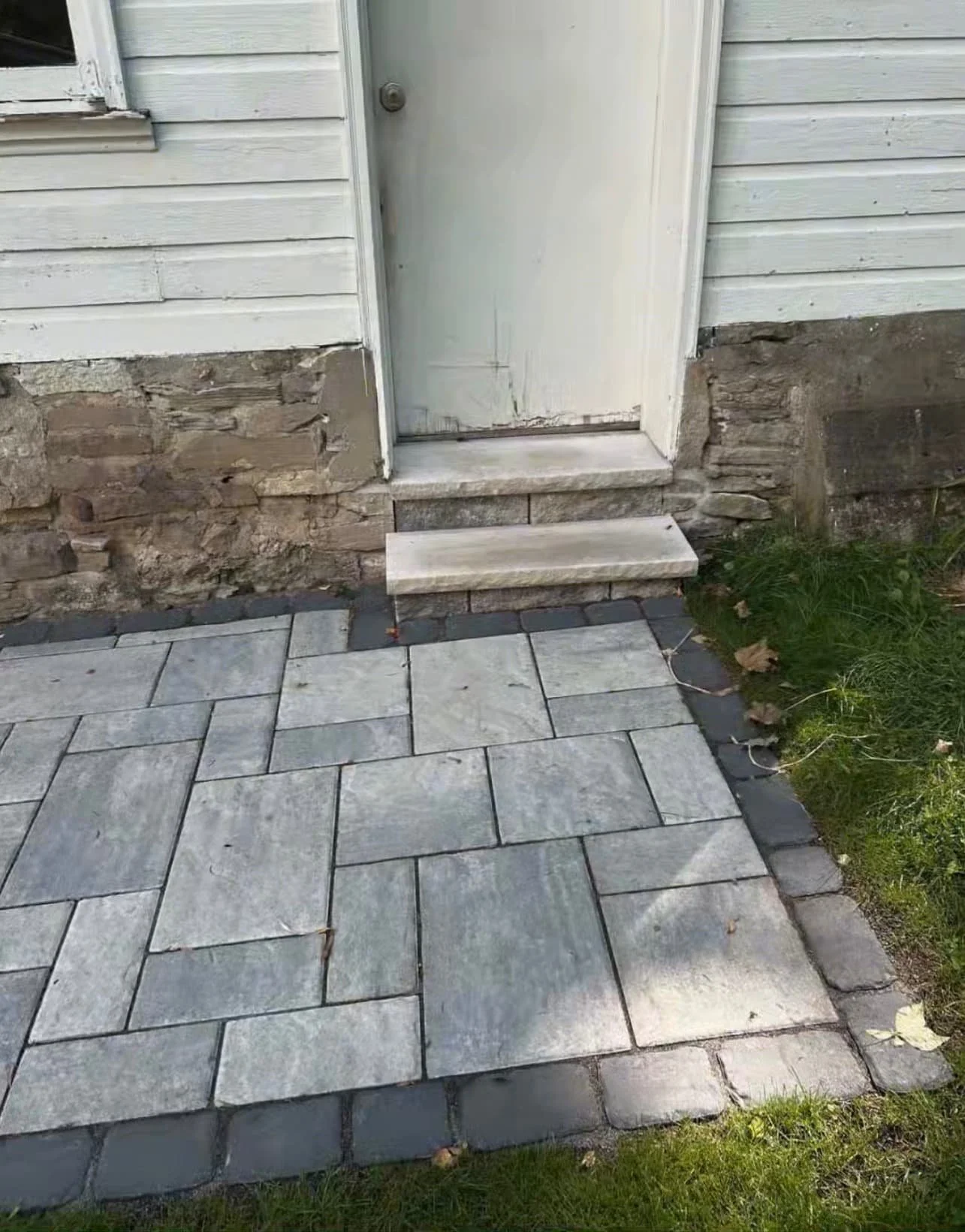 Curved front paver walkway at a Central New York home with dark border detail and a smooth transition to the entry.