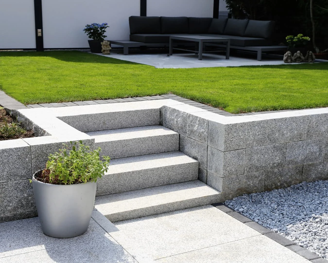 Modern stair inspiration with clean concrete steps connecting a patio area to an elevated lawn.