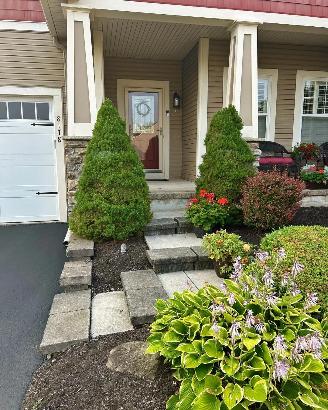 Natural stone entry steps and landscape bed completed by Pines and Pavers in Skaneateles Falls, New York.
