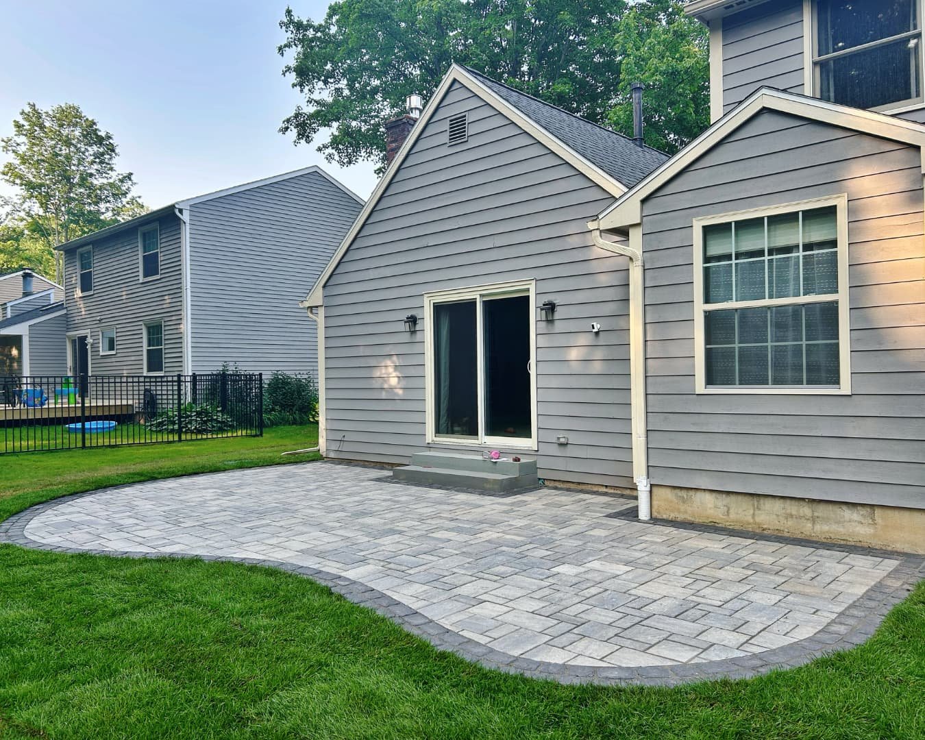 Completed paver patio by the back door by Pines and Pavers in Baldwinsville, New York.